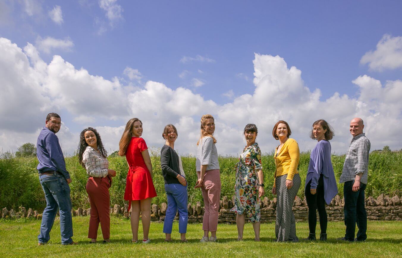 Clare Nash architecture team photo in a field with the wind blowing and blue sky