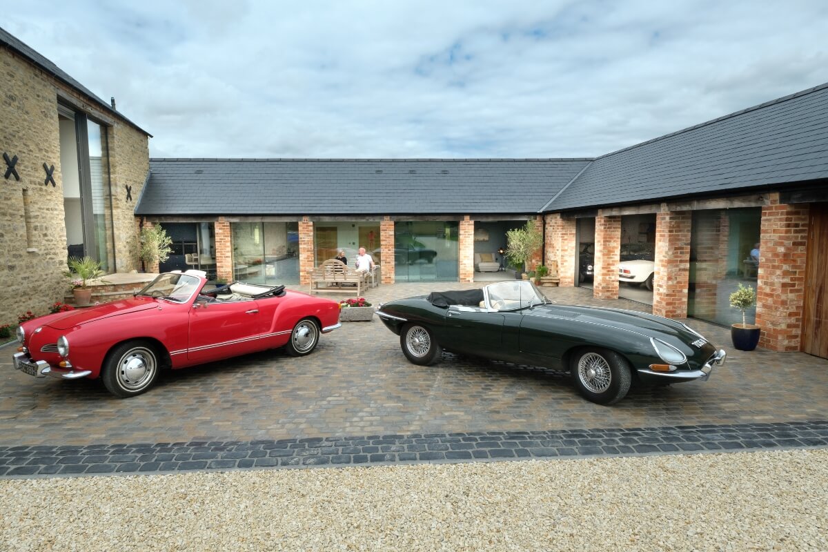 Beautiful old sports cars parked outside barn renovation